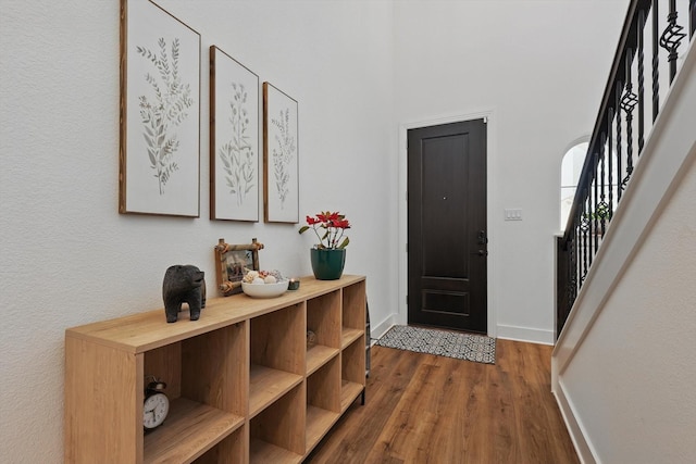 entryway featuring dark wood finished floors, stairway, and baseboards