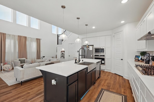 kitchen featuring white cabinets, a sink, pendant lighting, light countertops, and appliances with stainless steel finishes