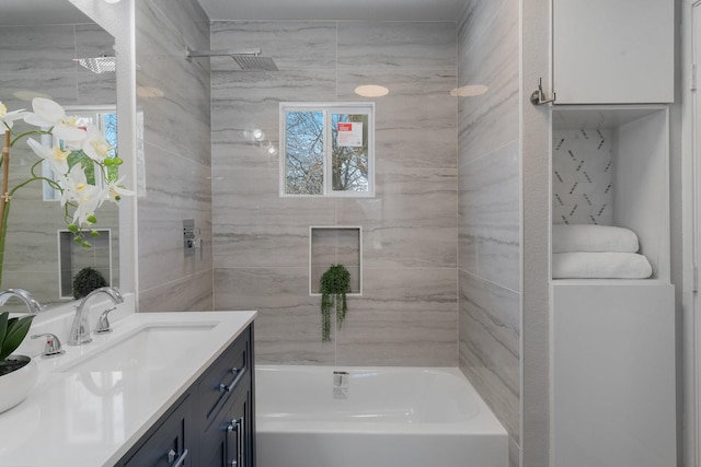 bathroom with shower / bathing tub combination, vanity, and a healthy amount of sunlight