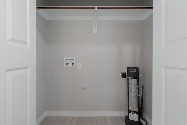 clothes washing area featuring baseboards, hookup for a gas dryer, wood finished floors, washer hookup, and electric dryer hookup