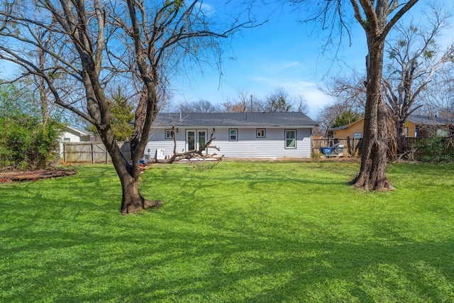 back of house featuring french doors, a lawn, and fence