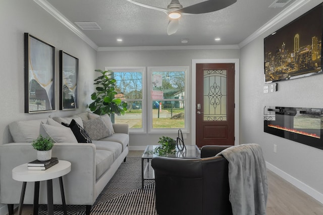 living room with a textured ceiling, ornamental molding, and visible vents