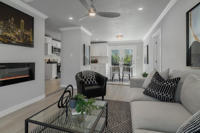 living room featuring light wood finished floors, baseboards, and ornamental molding