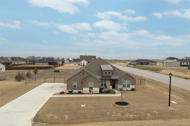 view of front of house with a residential view, a standing seam roof, fence, and metal roof