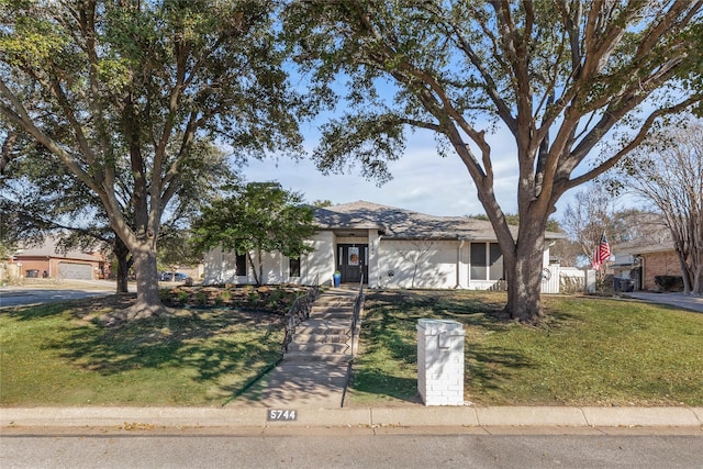 single story home featuring a front lawn