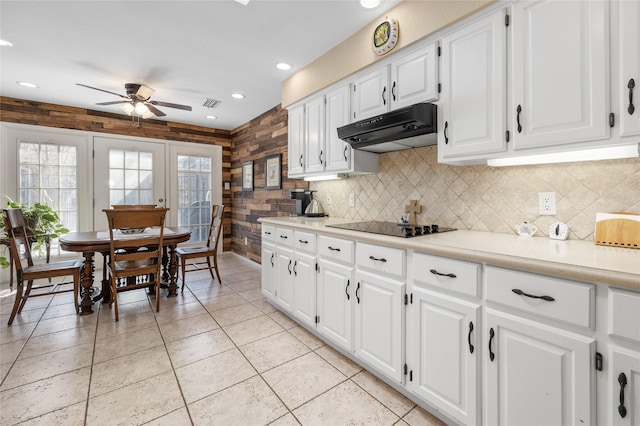 kitchen with black electric stovetop, light countertops, visible vents, white cabinets, and under cabinet range hood