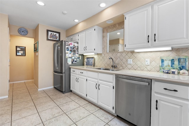 kitchen featuring stainless steel appliances, light countertops, white cabinetry, and a sink