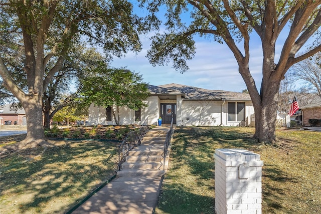 view of front of home with a shingled roof and a front lawn