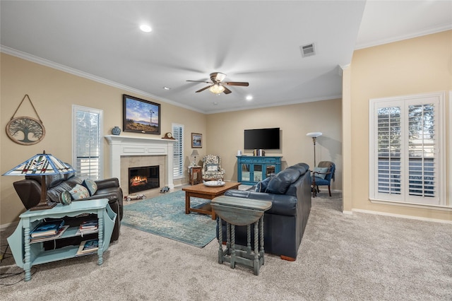 living area featuring visible vents, ornamental molding, a tiled fireplace, and light colored carpet