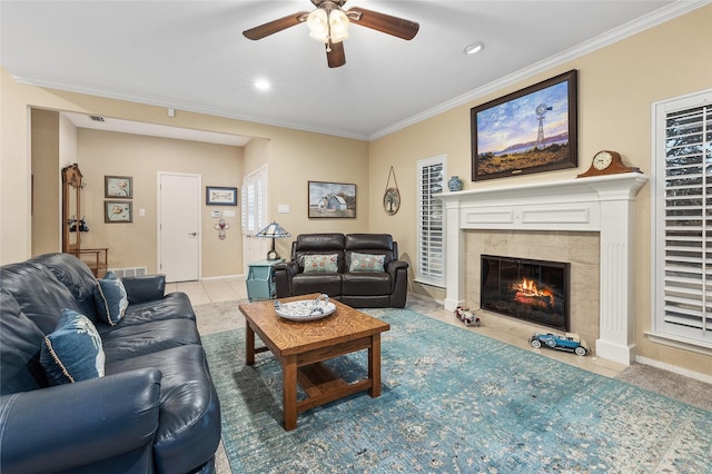 living room with visible vents, a premium fireplace, ornamental molding, a ceiling fan, and baseboards