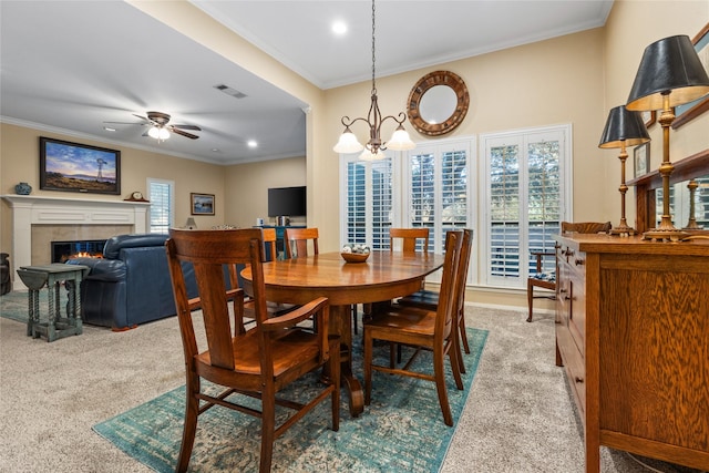 dining space featuring crown molding, a wealth of natural light, visible vents, and light colored carpet