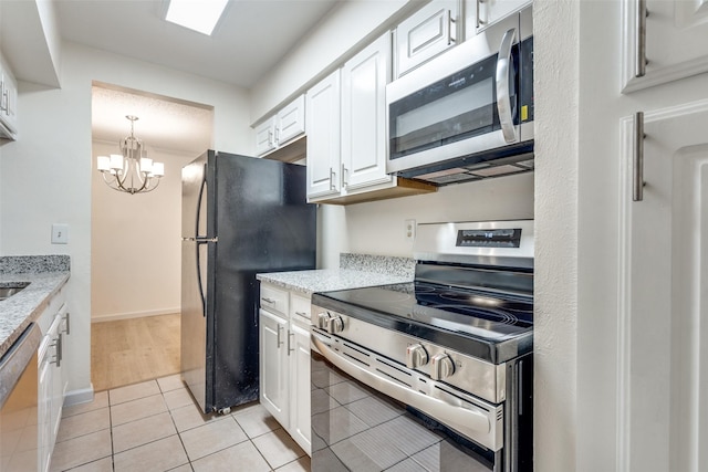 kitchen featuring light stone counters, appliances with stainless steel finishes, and white cabinetry