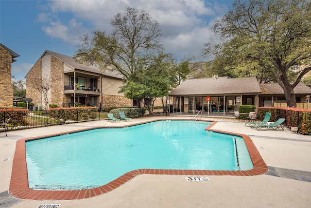 pool with fence and a patio