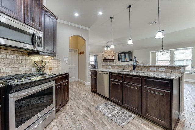 kitchen featuring tasteful backsplash, visible vents, appliances with stainless steel finishes, a sink, and light wood-type flooring