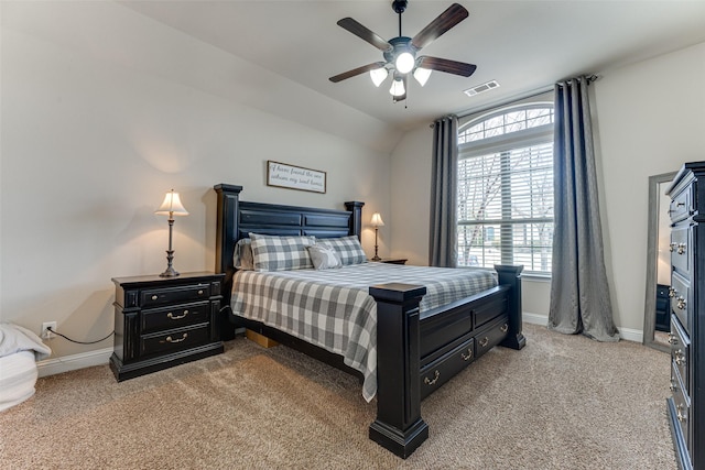 bedroom with light carpet, vaulted ceiling, visible vents, and baseboards