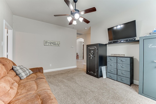 carpeted living area with arched walkways, ceiling fan, visible vents, and baseboards