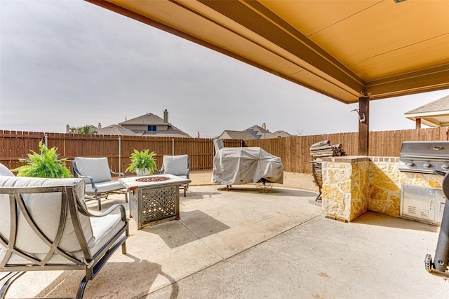 view of patio featuring exterior kitchen, a grill, a fire pit, and a fenced backyard