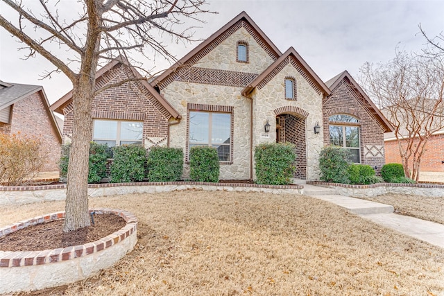 french provincial home with stone siding and brick siding