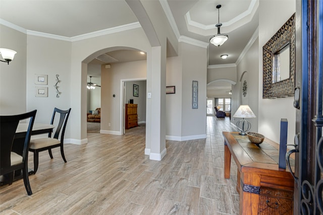 entrance foyer with arched walkways, light wood-style flooring, and baseboards