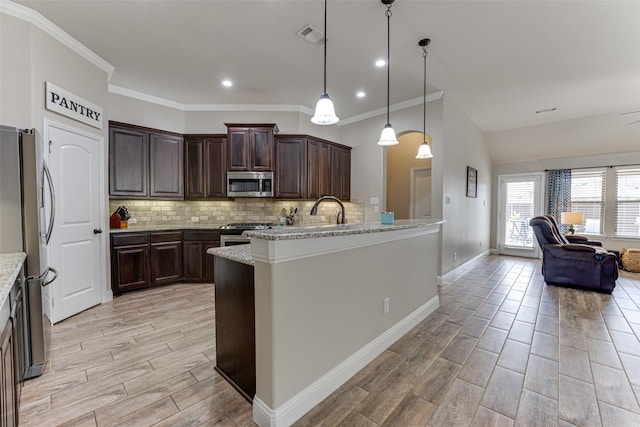 kitchen with backsplash, appliances with stainless steel finishes, wood tiled floor, open floor plan, and dark brown cabinetry