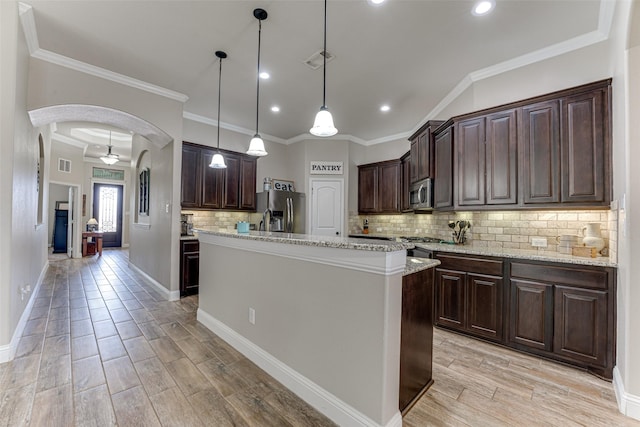 kitchen featuring stainless steel appliances, arched walkways, light wood-style flooring, and dark brown cabinets