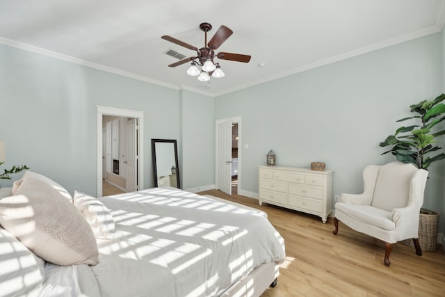 bedroom featuring crown molding, visible vents, light wood-style flooring, a ceiling fan, and baseboards