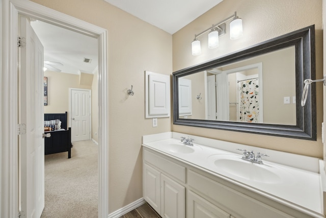 ensuite bathroom with double vanity, ensuite bath, a sink, and visible vents