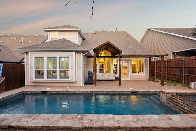 back of house at dusk with a fenced backyard, a fenced in pool, and an in ground hot tub