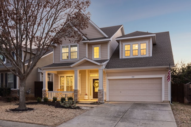 craftsman-style house featuring covered porch, driveway, roof with shingles, and a garage