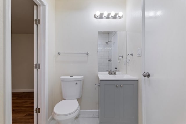 bathroom with baseboards, vanity, and toilet