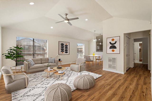 living room with lofted ceiling, baseboards, visible vents, and wood finished floors