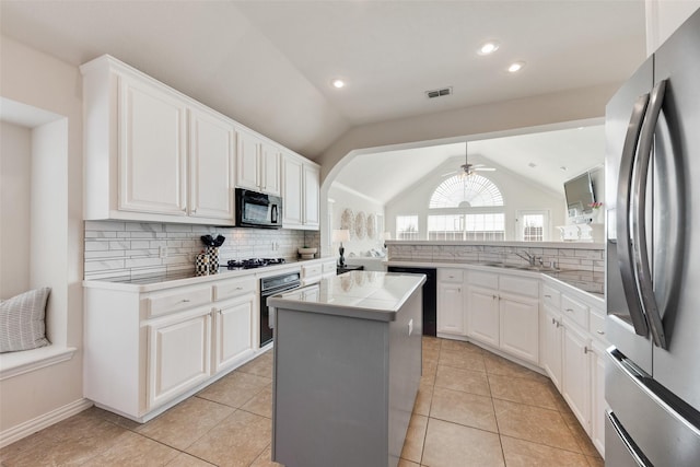 kitchen with black appliances, light countertops, white cabinets, and a center island