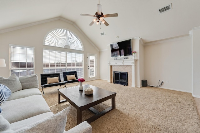 carpeted living room featuring high vaulted ceiling, ceiling fan, visible vents, and a tile fireplace