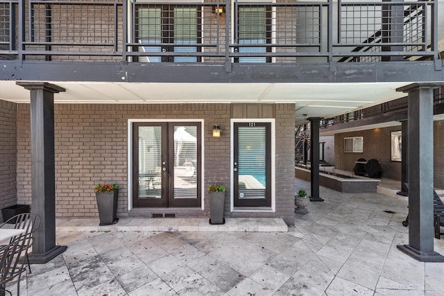 10211 Regal Oaks Dr Unit 121, Dallas, TX 75230 - entrance to property with french doors, a balcony, a patio, and brick siding