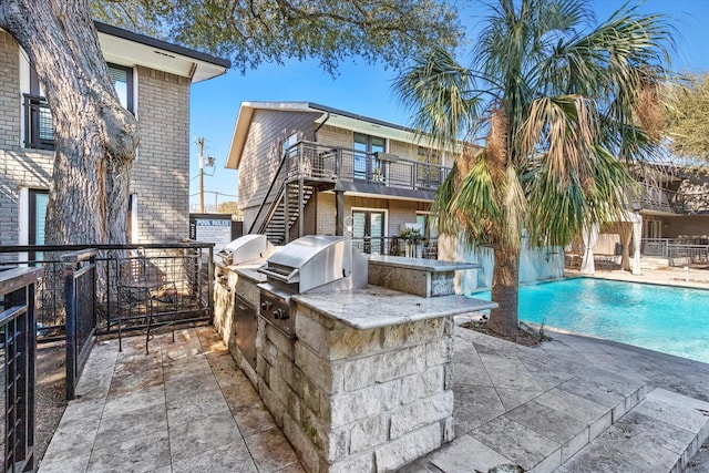 10211 Regal Oaks Dr Unit 121, Dallas, TX 75230 - rear view of house with area for grilling, stairway, brick siding, and a patio