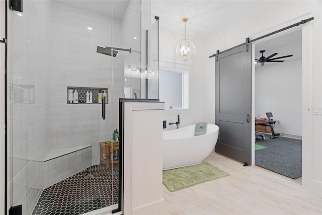 full bath featuring a stall shower, a freestanding tub, and baseboards