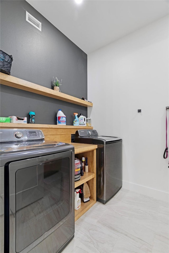 laundry area featuring laundry area, baseboards, visible vents, washer and clothes dryer, and marble finish floor