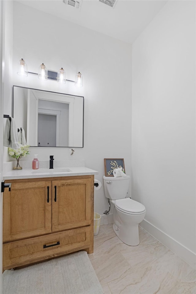 half bathroom with toilet, baseboards, and vanity