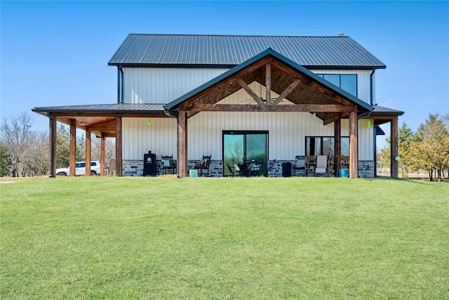 back of property featuring metal roof, a lawn, and board and batten siding