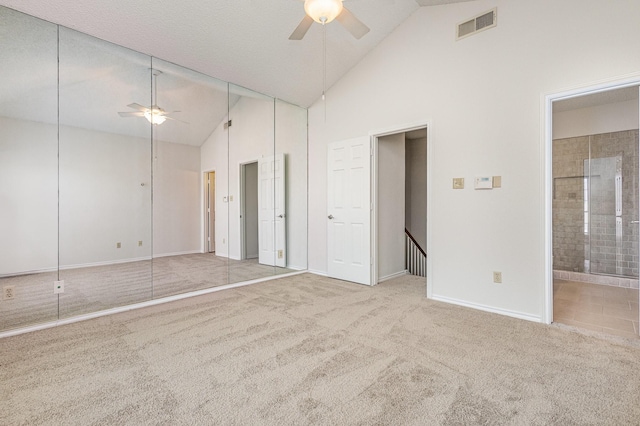 unfurnished bedroom with carpet, visible vents, ensuite bathroom, high vaulted ceiling, and baseboards