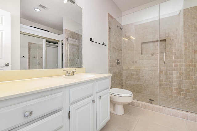 bathroom featuring toilet, tile patterned flooring, a textured ceiling, vanity, and a shower stall