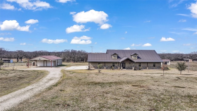 view of front of home with a detached garage, driveway, and a front lawn