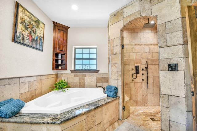 bathroom featuring a shower stall and a bath