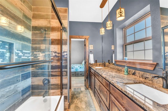 ensuite bathroom featuring double vanity, ensuite bath, bath / shower combo with glass door, and a sink