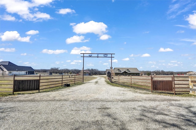 view of street featuring gravel driveway, a gated entry, and an enclosed area