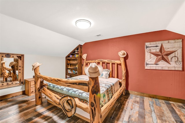 bedroom featuring vaulted ceiling, visible vents, hardwood / wood-style flooring, and baseboards