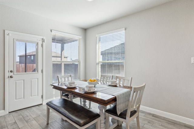 dining space with light wood-style flooring and baseboards