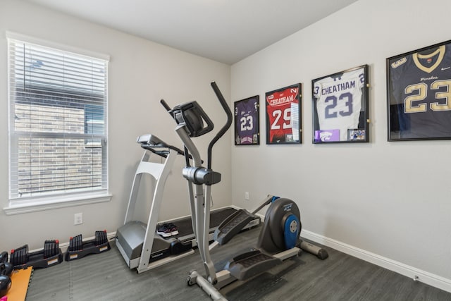 exercise room with plenty of natural light, baseboards, and dark wood-type flooring