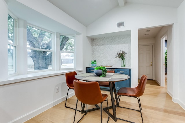 dining space featuring vaulted ceiling with beams, light wood finished floors, baseboards, and visible vents