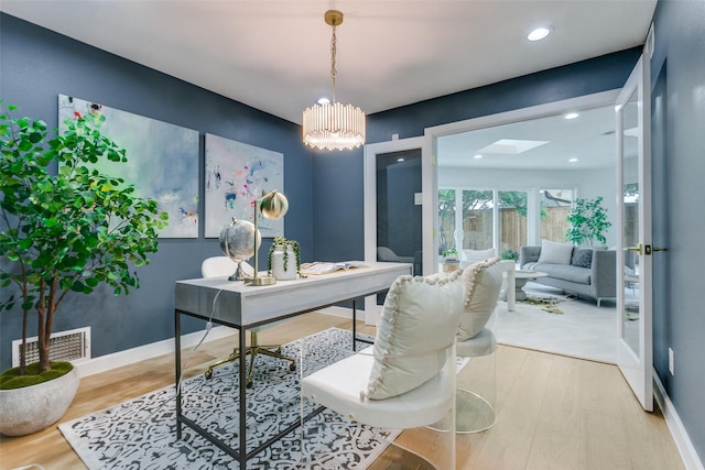 home office featuring recessed lighting, a skylight, wood finished floors, visible vents, and baseboards